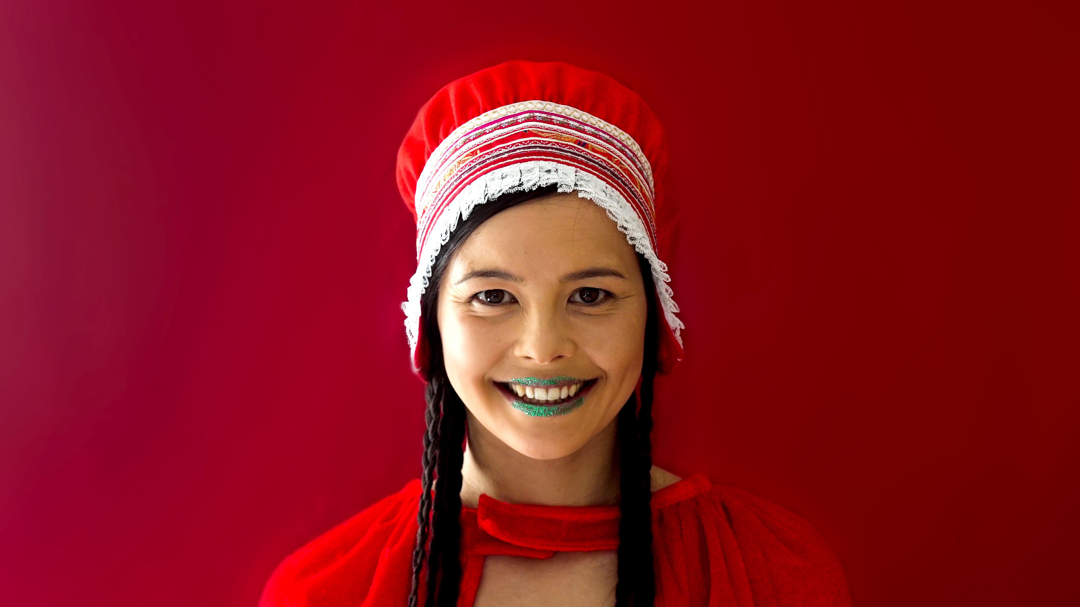 Leende kvinna med gröna läppar och samiska kläder